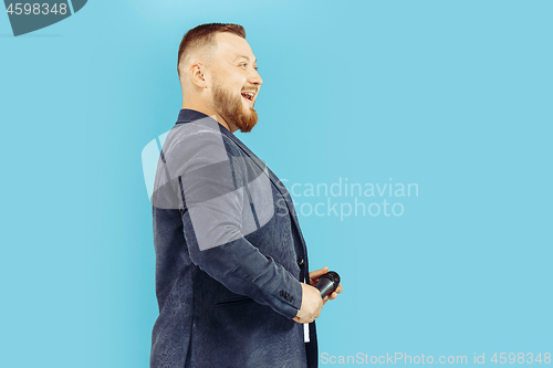 Image of Young man with microphone on blue background, leading concept