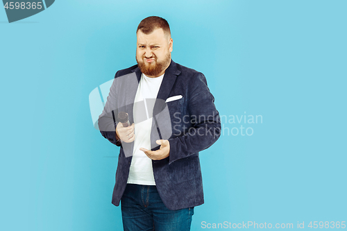 Image of Young man with microphone on blue background, leading concept