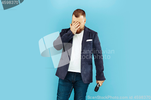 Image of Young man with microphone on blue background, leading concept