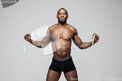 Image of Fit young man with beautiful torso isolated on gray background