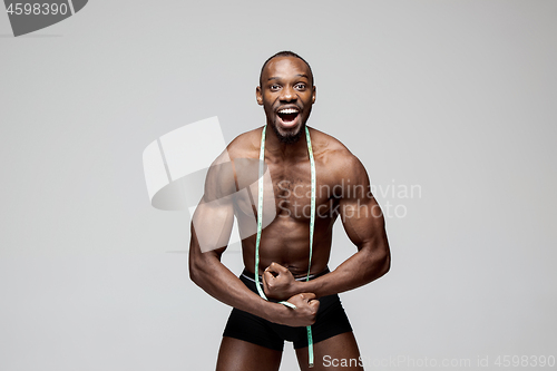 Image of Fit young man with beautiful torso isolated on gray background