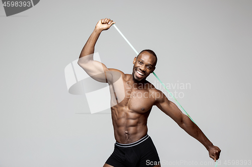 Image of Fit young man with beautiful torso isolated on gray background