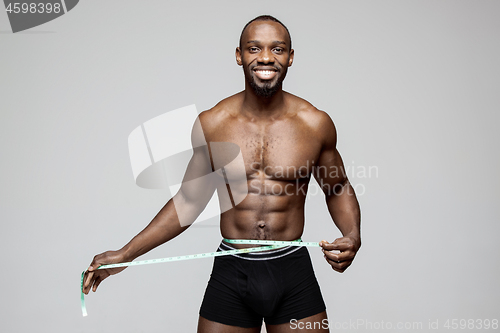 Image of Fit young man with beautiful torso isolated on gray background