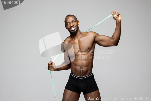 Image of Fit young man with beautiful torso isolated on gray background