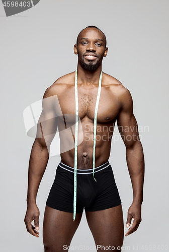 Image of Fit young man with beautiful torso isolated on gray background