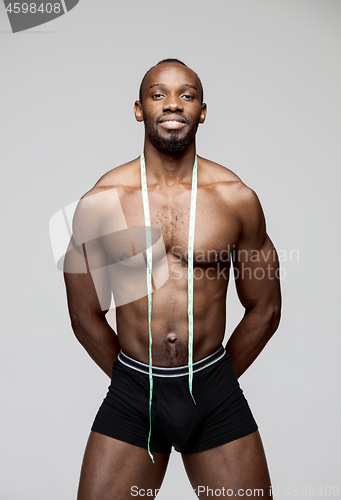 Image of Fit young man with beautiful torso isolated on gray background