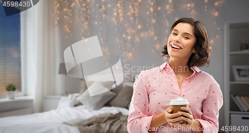 Image of happy young woman in pajama with cup of coffee