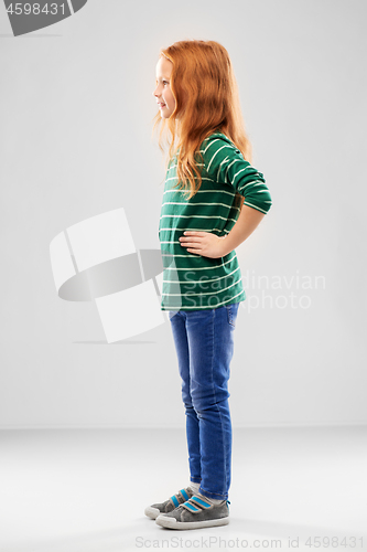 Image of smiling red haired girl posing in striped shirt