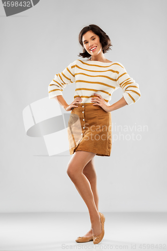 Image of young woman in striped pullover, skirt and shoes