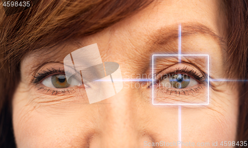 Image of close up of senior woman eyes with laser light