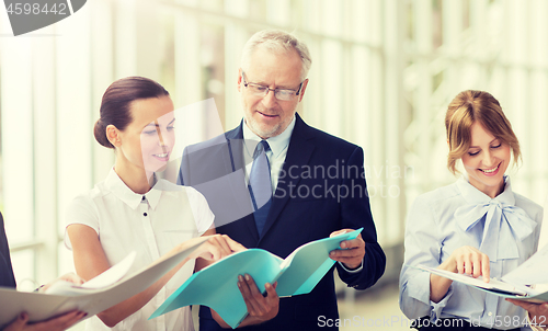 Image of business team with folders meeting at office