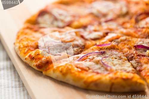 Image of close up of homemade pizza on wooden table