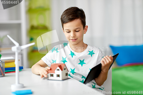 Image of boy with tablet, toy house and wind turbine