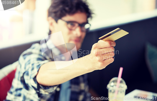 Image of man paying with credit card at cafe