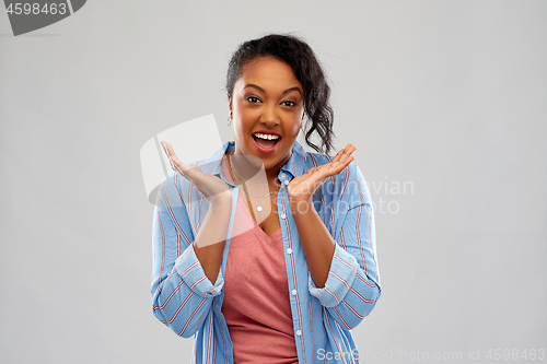 Image of surprised african american woman shrugging