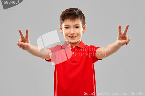 Image of smiling boy in red t-shirt showing peace gesture