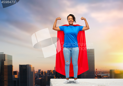 Image of happy african american woman in superhero red cape