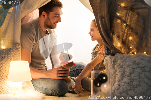 Image of happy family playing with toy in kids tent at home