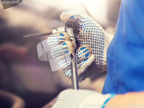 Image of mechanic man with wrench repairing car at workshop