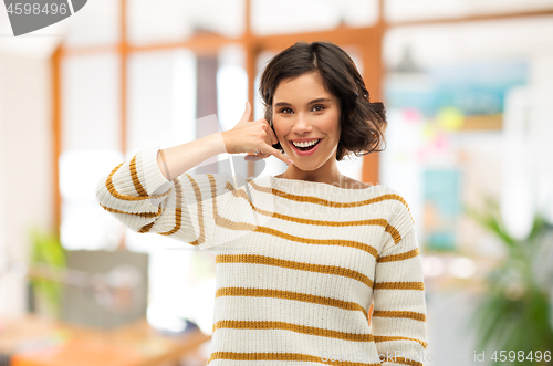 Image of happy smiling woman showing phone call gesture