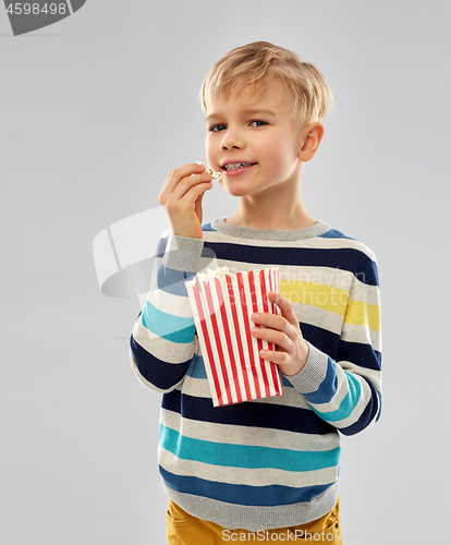 Image of little boy eating popcorn from paper bucket