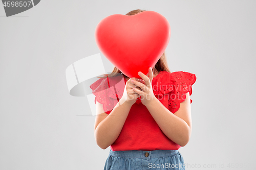 Image of girl hiding behind red heart shaped balloon