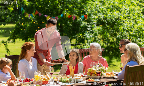 Image of happy family having dinner or summer garden party