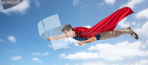 Image of man in red superhero cape flying over sky