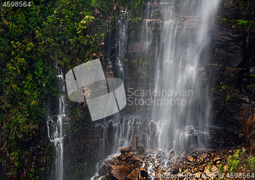 Image of Waterfall cascading onto a rocky rubble at its cliff base