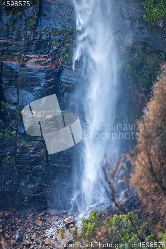 Image of Waterfall tumbling down onto boulders at its base