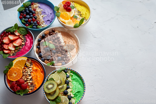 Image of Various healthy fresh smoothies or yogurts in bowls. With strawberries, kiwi, chia, blackberries