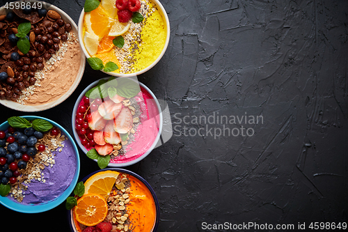 Image of Various healthy fresh smoothies or yogurts in bowls. With strawberries, kiwi, chia, blackberries