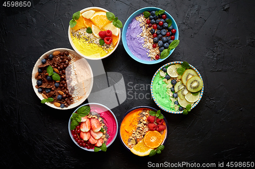 Image of Various healthy fresh smoothies or yogurts in bowls. With strawberries, kiwi, chia, blackberries