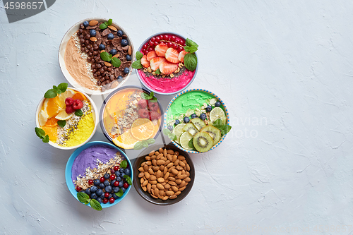 Image of Various healthy fresh smoothies or yogurts in bowls. With strawberries, kiwi, chia, blackberries