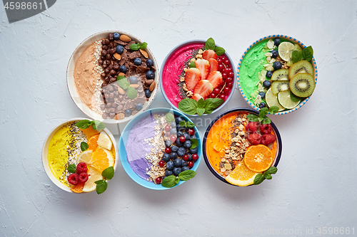 Image of Various healthy fresh smoothies or yogurts in bowls. With strawberries, kiwi, chia, blackberries