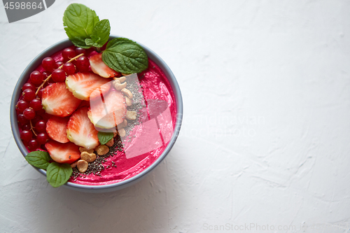 Image of Summer berry smoothie or yogurt bowl with strawberries, red curr