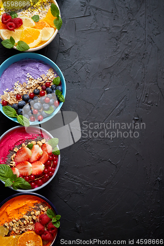 Image of Various healthy fresh smoothies or yogurts in bowls. With strawberries, kiwi, chia, blackberries