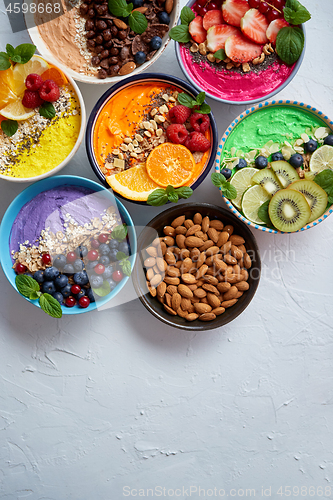 Image of Various healthy fresh smoothies or yogurts in bowls. With strawberries, kiwi, chia, blackberries