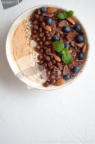 Image of Chocolate and blueberry smoothie or yogurt. With cocoa cornflake