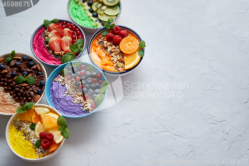 Image of Various healthy fresh smoothies or yogurts in bowls. With strawberries, kiwi, chia, blackberries