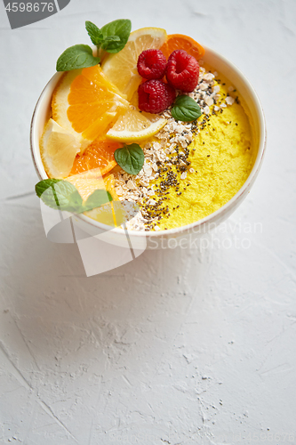 Image of Tasty orange fresh smoothie or yogurt served in bowl. With raspberries, orange slices, chia seeds