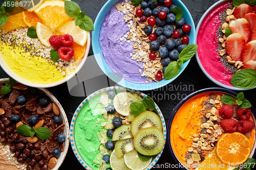 Image of Various healthy fresh smoothies or yogurts in bowls. With strawberries, kiwi, chia, blackberries