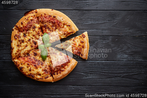 Image of Sliced pizza Margarita with basil leafs