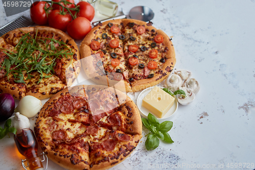 Image of Three american style pizzas served on a table