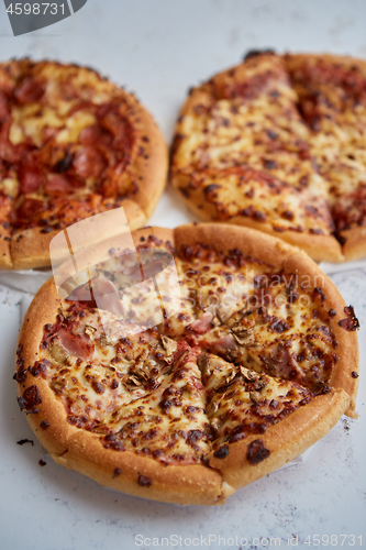 Image of Three american style pizzas served on a table