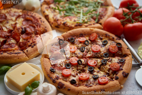 Image of Three american style pizzas served on a table