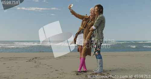 Image of Girls having time and taking selfie on a beach