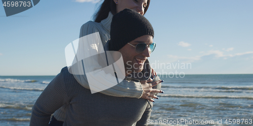 Image of couple having fun at beach during autumn