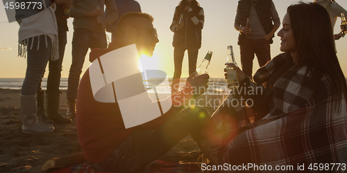 Image of Friends having fun at beach on autumn day