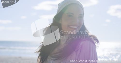 Image of Girl In Autumn Clothes Smiling on beach